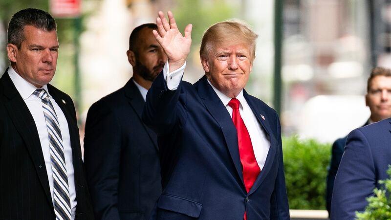 Former President Donald Trump waves as he departs Trump Tower, Wednesday, Aug. 10, 2022, in...