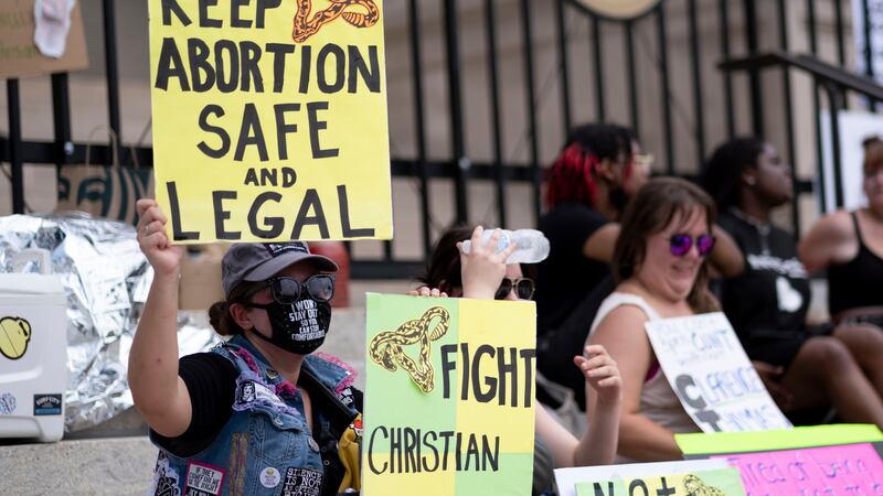 FILE - A small group, including Stephanie Batchelor, left, sits on the steps of the Georgia...