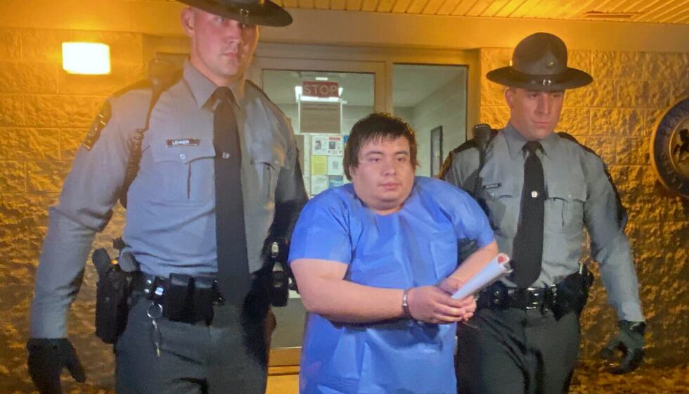 Adrian Oswaldo Sura Reyes, 24, of Nescopeck, Pa., is led from the state police barracks at...