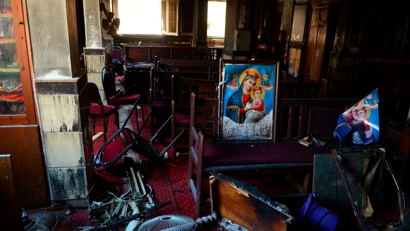 Burned furniture, including wooden tables and chairs, and religious images are seen at the...